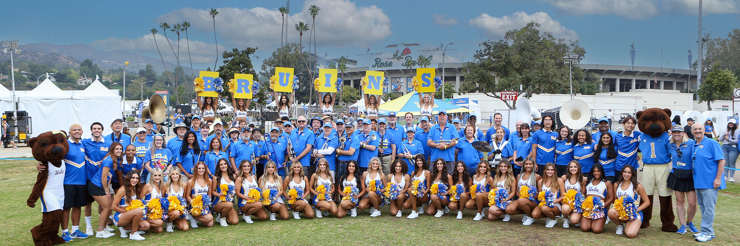 UCLA Alumni Band with spirit squad standing in front of the Rose Bowl